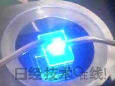   發(fā)光試驗中的LED元件。基板尺寸：1cm見方，元件尺寸：0.3mm見方，注入電流：約200mA，中心波長：450nm 